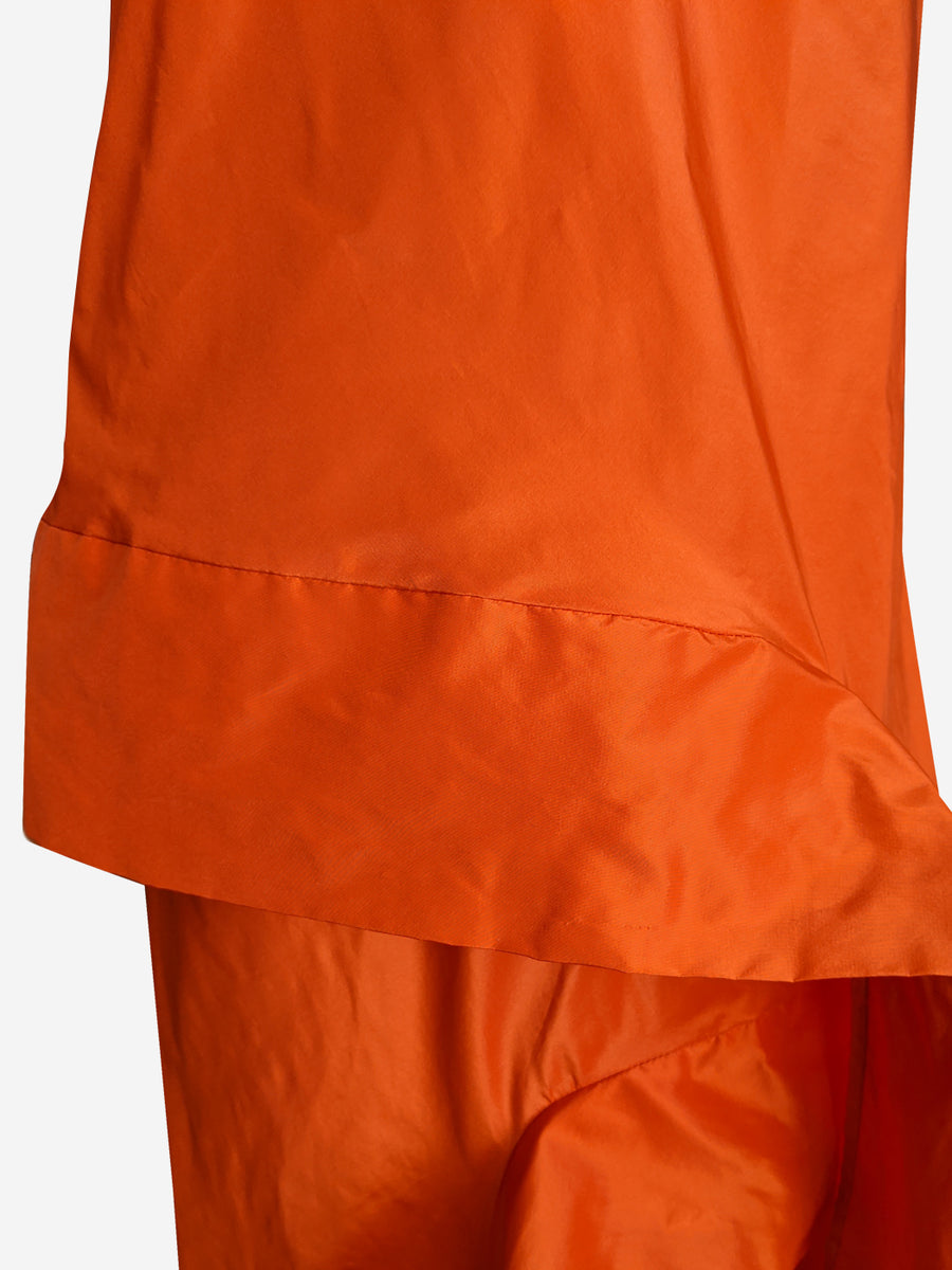 Detail of bright orange silk taffeta asymmetric long evening dress