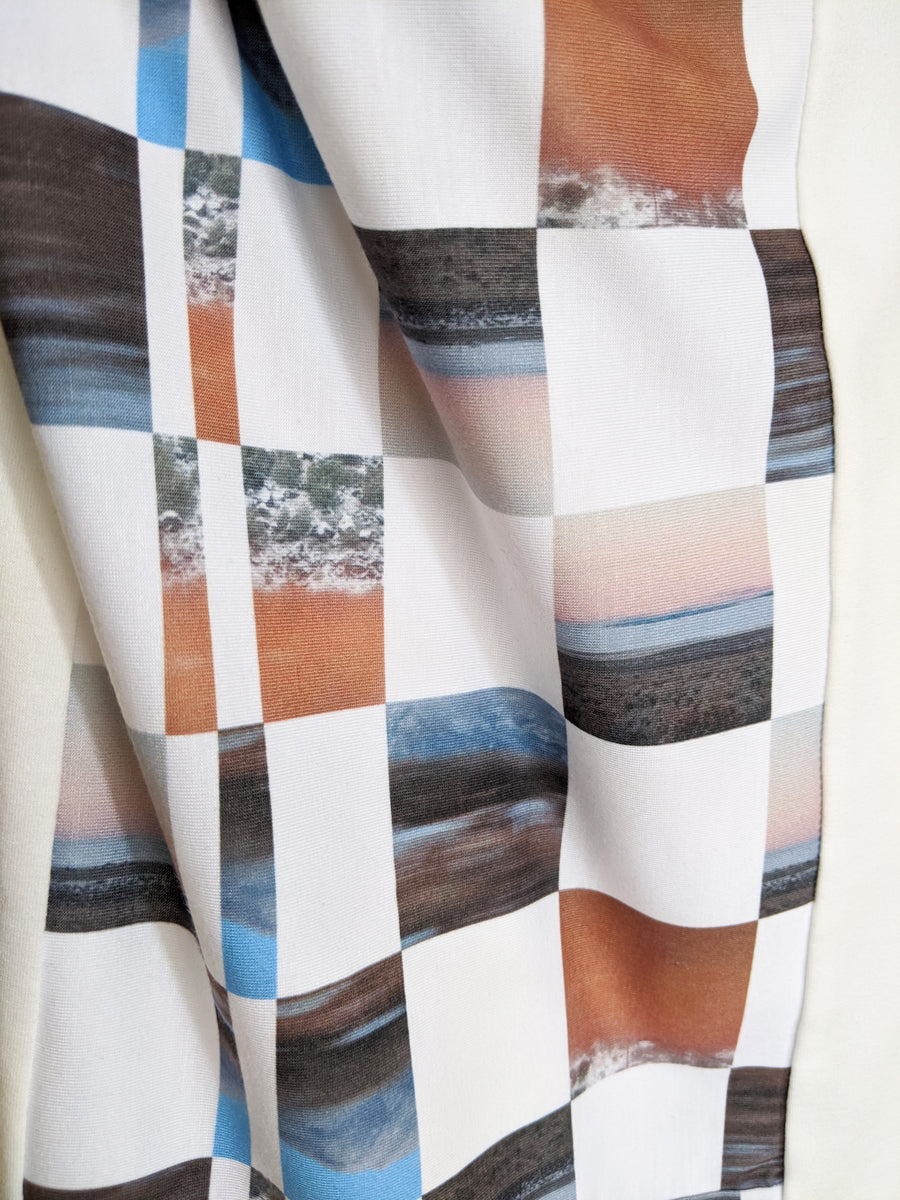 Detail of designer dress with split dolman sleeves, original print, and mock turtleneck.